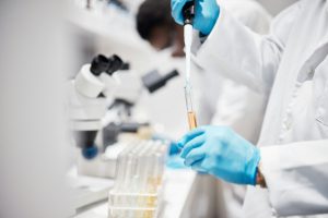 Hands, science and tube for research in laboratory with liquid, medicine or pharma product with glo